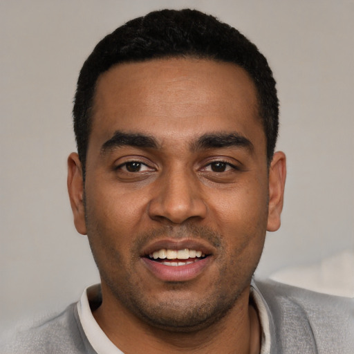 Joyful black young-adult male with short  black hair and brown eyes