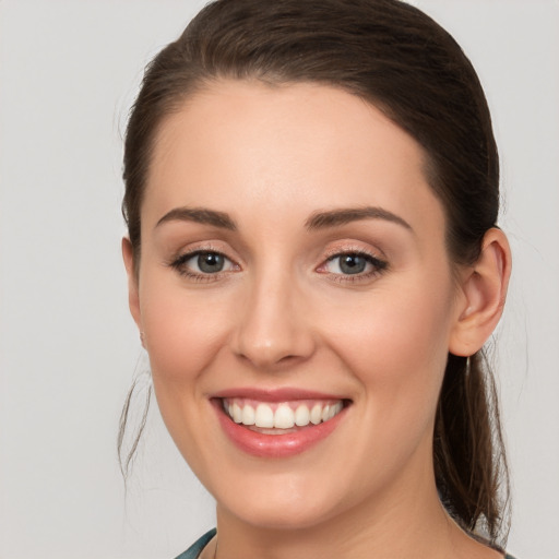 Joyful white young-adult female with long  brown hair and grey eyes