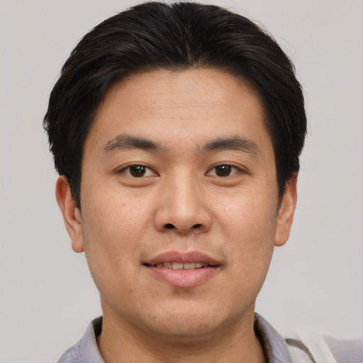 Joyful asian young-adult male with short  brown hair and brown eyes