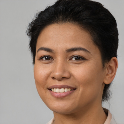 Joyful latino young-adult female with short  brown hair and brown eyes