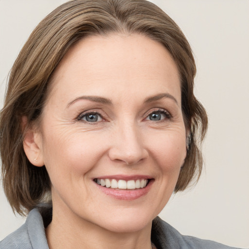 Joyful white adult female with medium  brown hair and grey eyes