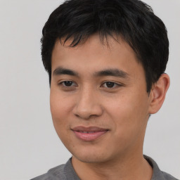 Joyful asian young-adult male with short  black hair and brown eyes