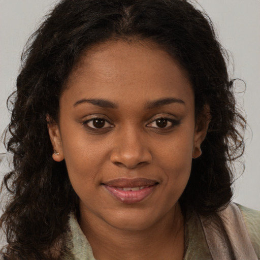 Joyful black young-adult female with long  brown hair and brown eyes