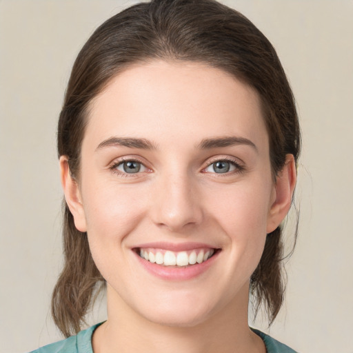 Joyful white young-adult female with medium  brown hair and green eyes