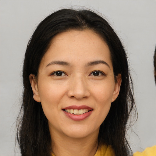 Joyful asian young-adult female with long  brown hair and brown eyes