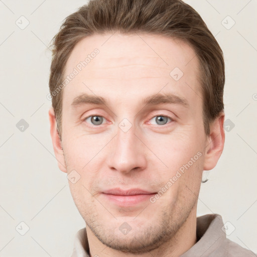 Joyful white young-adult male with short  brown hair and grey eyes