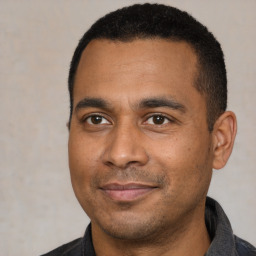 Joyful latino young-adult male with short  black hair and brown eyes