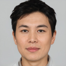 Joyful asian young-adult male with short  black hair and brown eyes