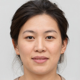 Joyful asian young-adult female with medium  brown hair and brown eyes