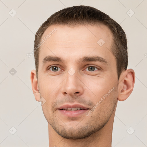 Joyful white young-adult male with short  brown hair and brown eyes