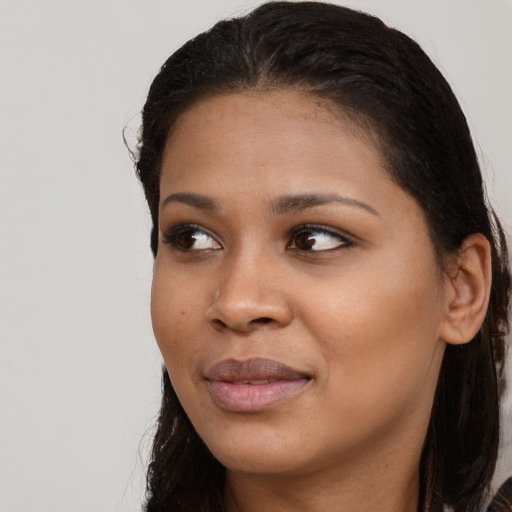 Joyful black young-adult female with long  brown hair and brown eyes