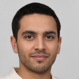 Joyful latino young-adult male with short  brown hair and brown eyes