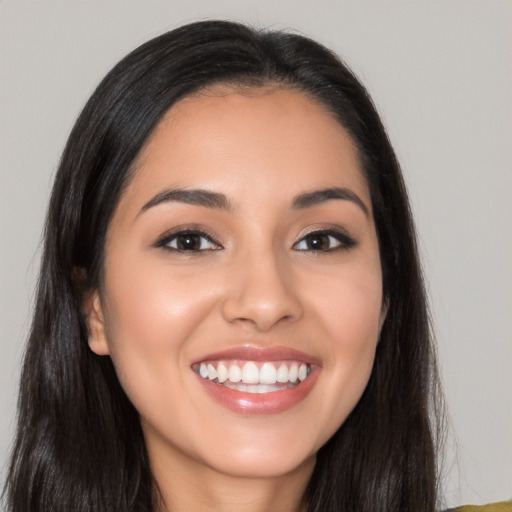 Joyful latino young-adult female with long  black hair and brown eyes