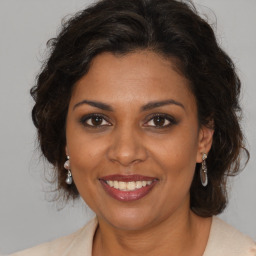 Joyful black adult female with medium  brown hair and brown eyes