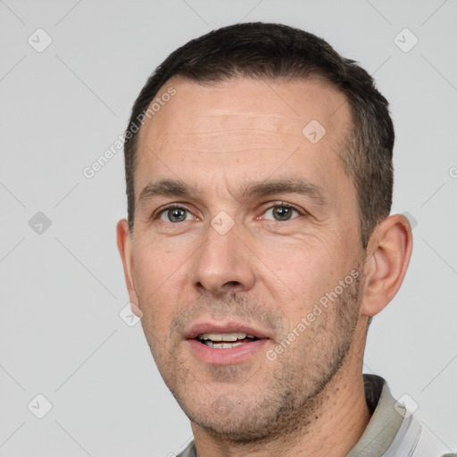 Joyful white adult male with short  black hair and brown eyes