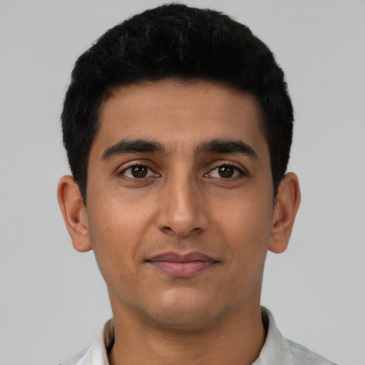 Joyful latino young-adult male with short  black hair and brown eyes