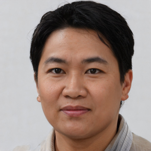 Joyful asian young-adult male with short  brown hair and brown eyes