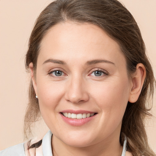 Joyful white young-adult female with medium  brown hair and grey eyes