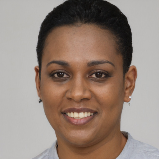 Joyful black young-adult female with short  black hair and brown eyes