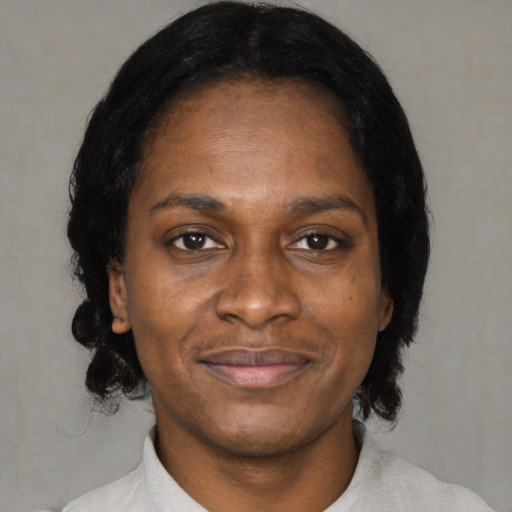 Joyful black adult female with medium  black hair and brown eyes