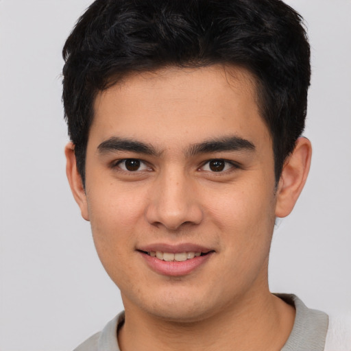 Joyful asian young-adult male with short  brown hair and brown eyes
