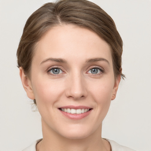 Joyful white young-adult female with short  brown hair and grey eyes