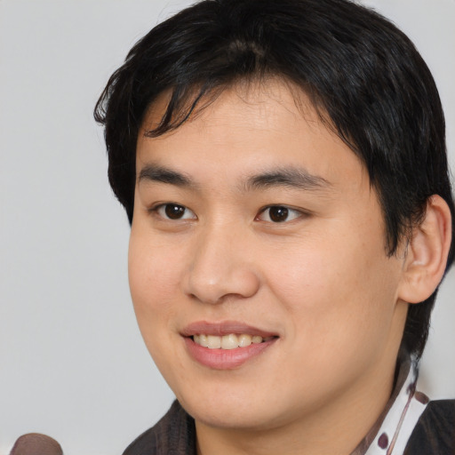 Joyful asian young-adult male with short  brown hair and brown eyes
