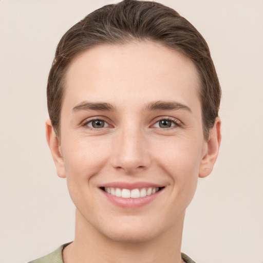 Joyful white young-adult female with short  brown hair and grey eyes