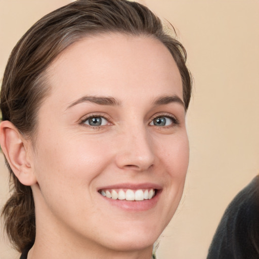 Joyful white young-adult female with medium  brown hair and grey eyes