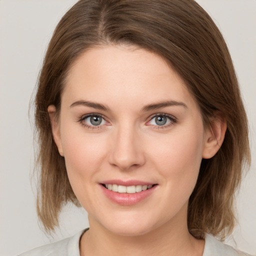 Joyful white young-adult female with medium  brown hair and grey eyes