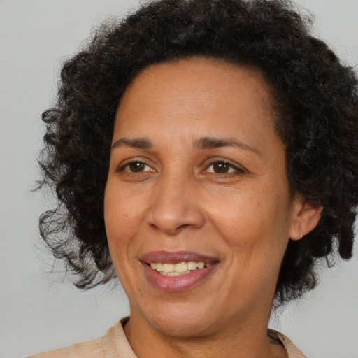 Joyful latino adult female with medium  brown hair and brown eyes