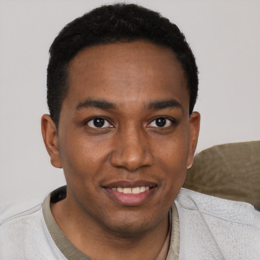 Joyful black young-adult male with short  black hair and brown eyes