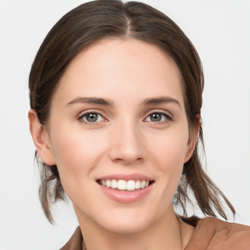 Joyful white young-adult female with medium  brown hair and grey eyes