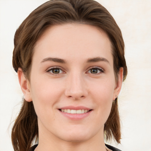 Joyful white young-adult female with medium  brown hair and grey eyes