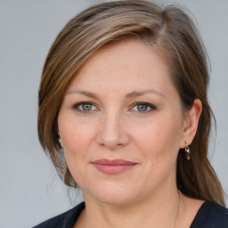 Joyful white adult female with medium  brown hair and blue eyes