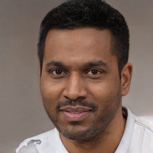Joyful black young-adult male with short  black hair and brown eyes