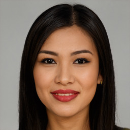 Joyful latino young-adult female with long  brown hair and brown eyes