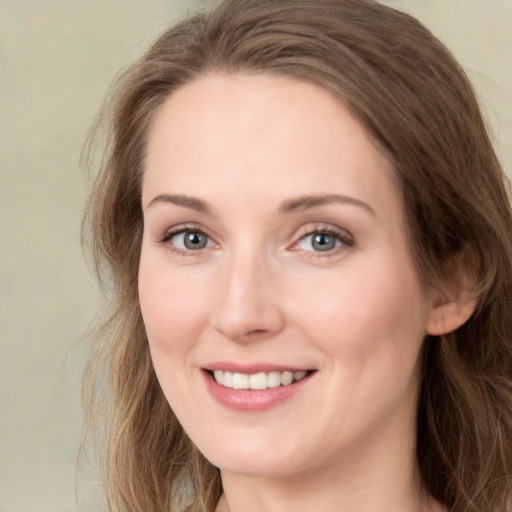 Joyful white young-adult female with long  brown hair and green eyes