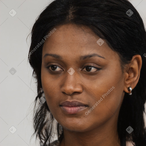 Joyful black young-adult female with long  black hair and brown eyes