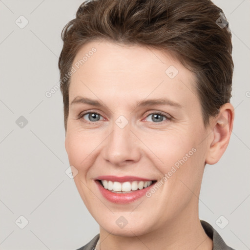 Joyful white young-adult female with short  brown hair and grey eyes