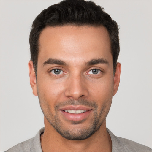 Joyful white young-adult male with short  black hair and brown eyes