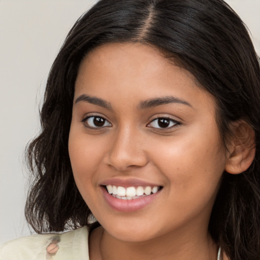 Joyful latino young-adult female with long  brown hair and brown eyes