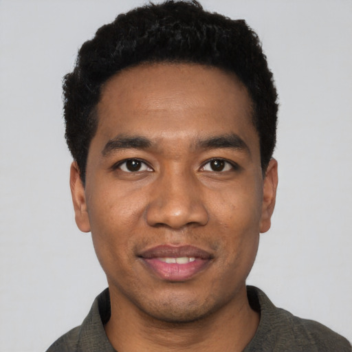 Joyful black young-adult male with short  black hair and brown eyes