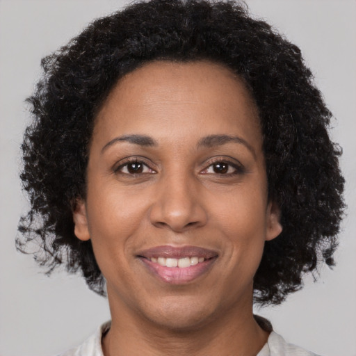 Joyful black young-adult female with short  brown hair and brown eyes