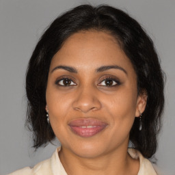 Joyful black adult female with medium  brown hair and brown eyes