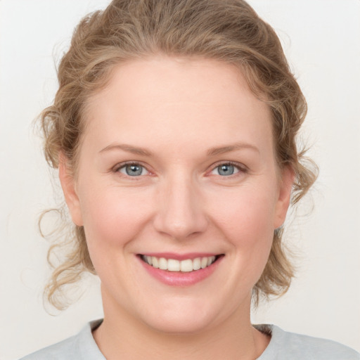 Joyful white young-adult female with medium  brown hair and blue eyes