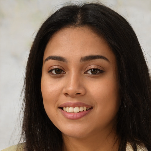 Joyful latino young-adult female with long  brown hair and brown eyes