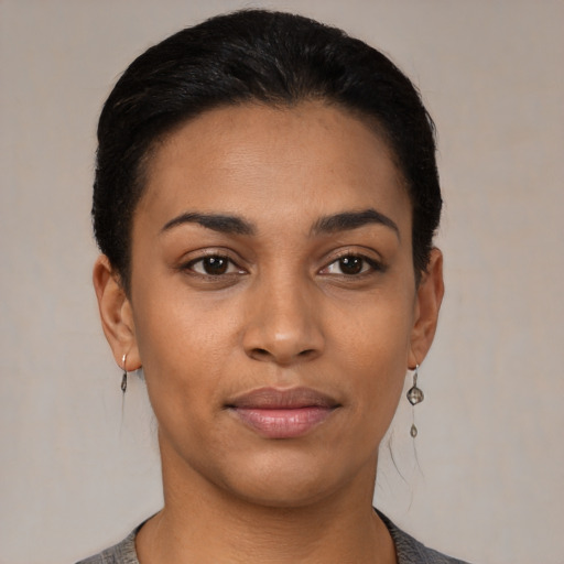 Joyful latino young-adult female with short  black hair and brown eyes