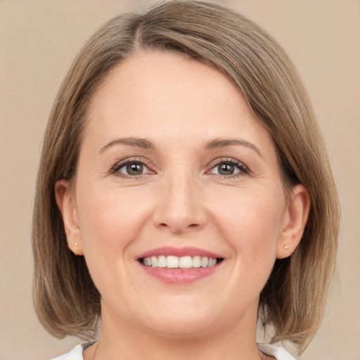 Joyful white young-adult female with medium  brown hair and grey eyes