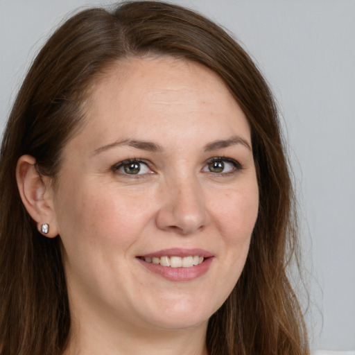 Joyful white adult female with long  brown hair and grey eyes